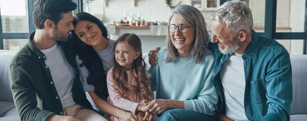Multi-generational family smiling on couch